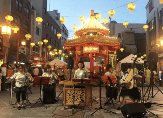 中秋節の神輿の周りで演奏する女性 神戸経済新聞HP